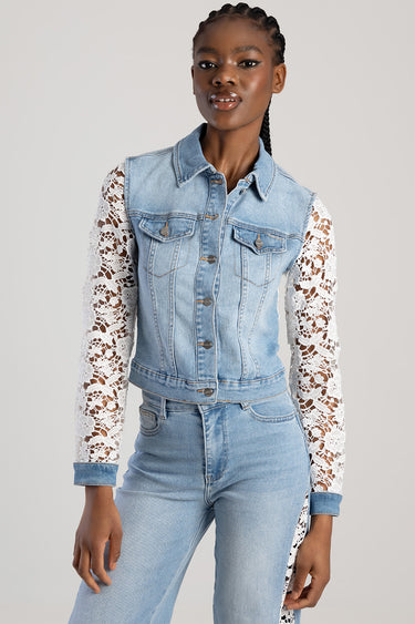 woman modeling a light wash denim jacket with white lace long sleeves and metal front buttons