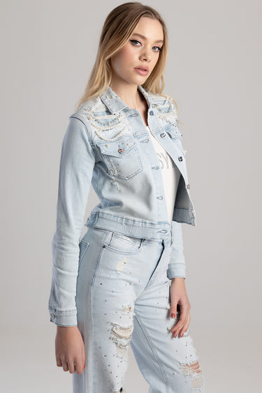 woman wearing a light wash denim jacket with pearl bead detailing and ripped jeans