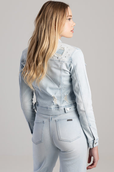 woman wearing a light blue distressed denim jacket and jeans, back view
