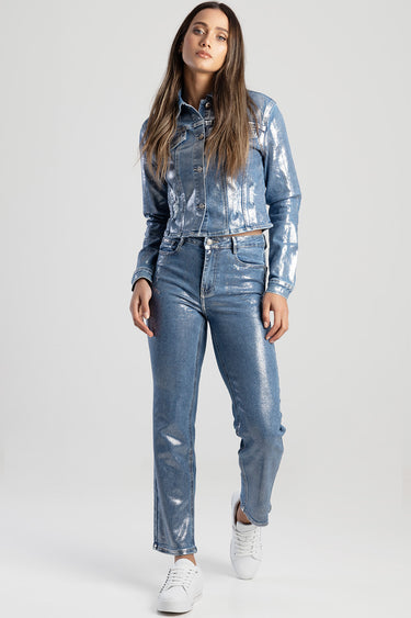 woman wearing a shiny light blue denim jacket and matching jeans with white sneakers