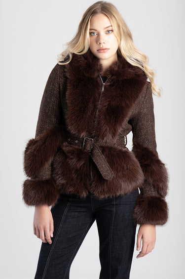 woman wearing a dark brown faux fur jacket with a large fur collar, fur cuffs, and a belted waist