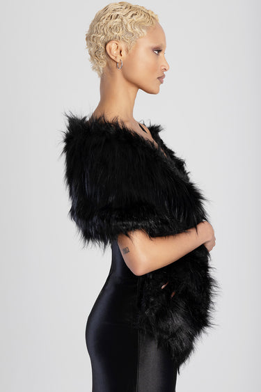 side profile of a woman with short blonde curls wearing a black faux fur wrap over a satin dress