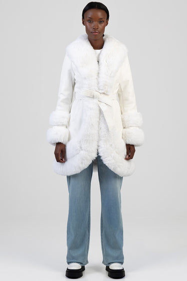 Blue Jean Traders white faux fur trimmed coat with belt and large fur cuffs worn by a model in light wash jeans and white