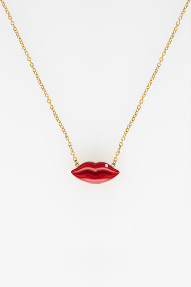 gold chain necklace with red lip pendant and small crystal accent