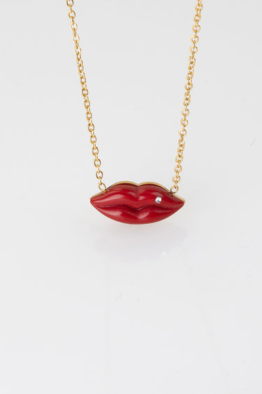 gold tone chain necklace with red enamel lips pendant and a small crystal