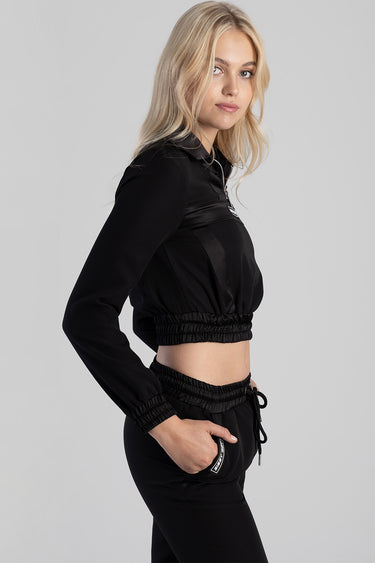 woman in black cropped jacket with elastic hem and matching jogger pants, side view, blue jean traders