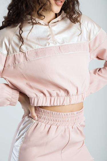 pink and ivory cropped track top with a half zipper, elastic hem, and a large stitched logo across the chest