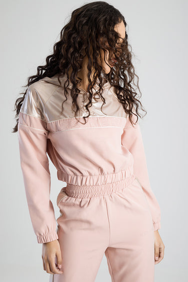 back view of a pastel pink track top with a beige yoke and matching jogger pants, elastic waist and gathered cuffs