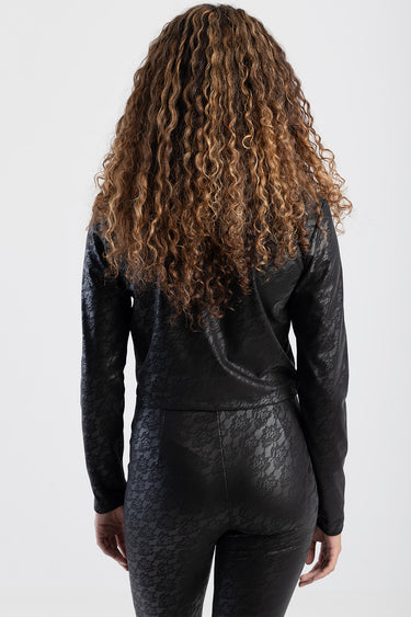 woman in black lace jacket and matching pants, back view