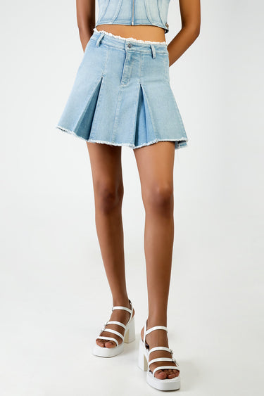 light washed denim pleated mini skirt with frayed hem and belt loops on a model wearing white sandals