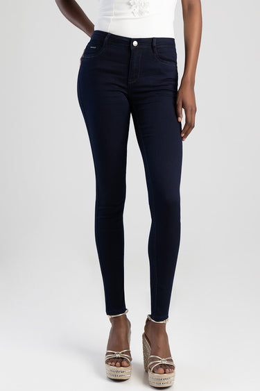 Blue Jean Traders dark indigo skinny jeans on a model with a white top and wedge sandals