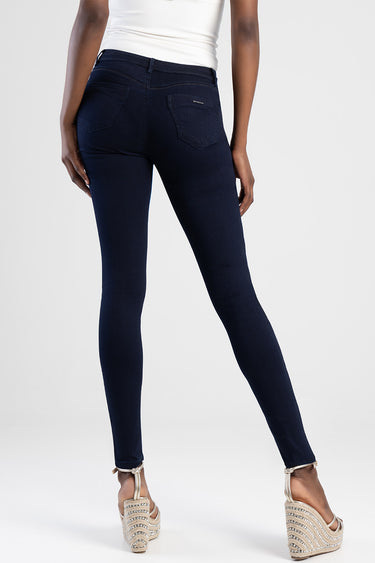 woman wearing dark blue skinny jeans from Blue Jean Traders, back view shows pockets and slim fit, with white top