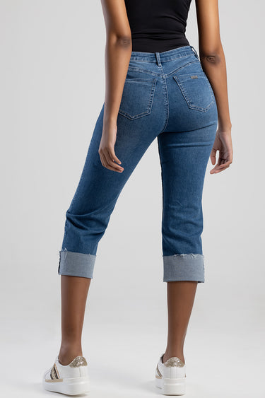 back view of a model wearing blue jean traders denim jeans with rolled cuffs, two back pockets and a small brand tag