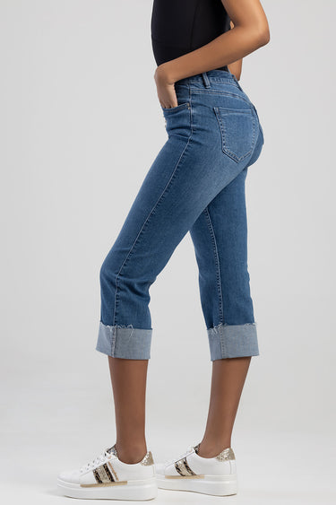 woman wearing blue denim jeans with rolled cuffs and back pockets, paired with white sneakers
