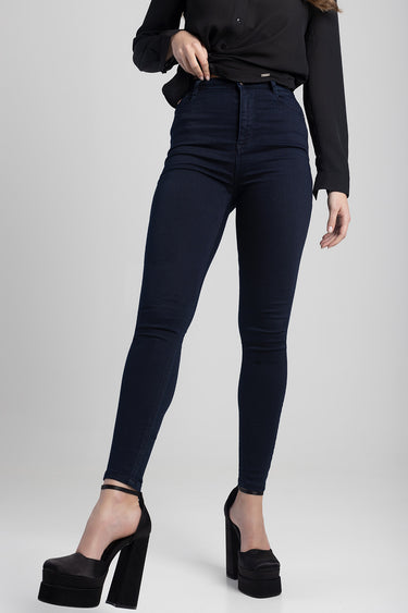 woman wearing dark blue skinny jeans with a black blouse and black platform heels