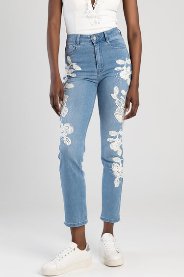 light blue denim jeans with white floral embroidery down both legs, high rise, slim fit, shown with white sneakers