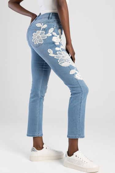 Blue Jean Traders jeans with white floral embroidery along the leg and back pocket paired with white platform sneakers