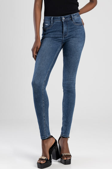 woman wearing blue denim skinny jeans with a black top and platform sandals
