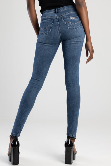 back view of a person in blue skinny jeans with embroidered back pockets and a small brand badge, paired with a black top