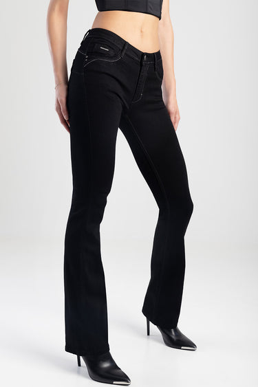black bootcut jeans on a model with front pockets and contrast stitching, paired with black heeled boots