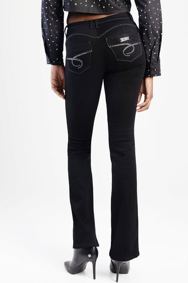 black bootcut jeans with rhinestone detailing on back pockets and a small brand patch, paired with a dark polka dot shirt