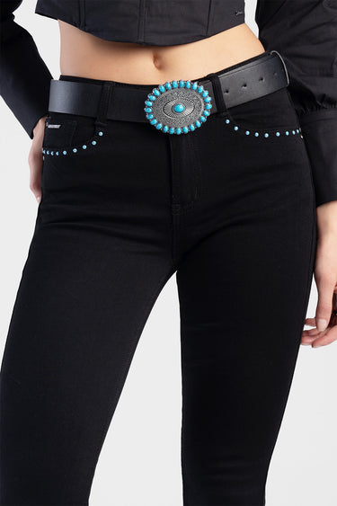 woman wearing black jeans with a turquoise belt and a round turquoise stone buckle with bead detailing