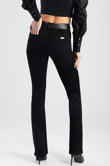 woman in black denim jeans with a belt, back view showing two back pockets and a small metal tag