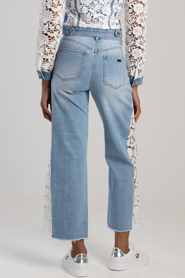 back view of light blue wide leg jeans with lace side panels and two back pockets, paired with white sneakers