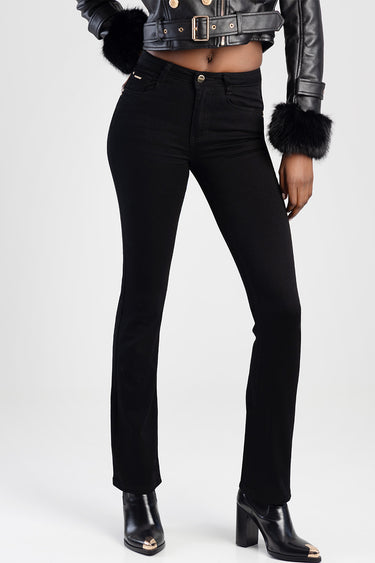 woman in black high waist jeans with a front button and pockets, paired with a cropped leather jacket and heeled boots