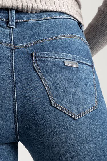 blue denim jeans close up of back pocket with contrast stitching and a small metal brand plate