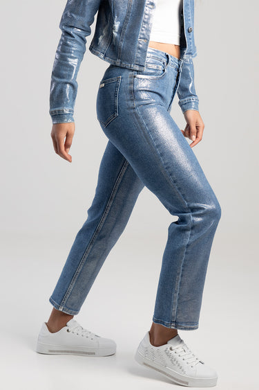 side view of a model wearing blue metallic straight jeans with white sneakers and a denim jacket