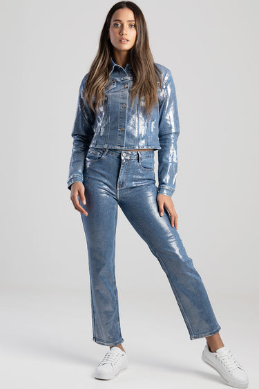 woman wearing metallic blue straight jeans with a matching denim jacket by blue jean traders, white sneakers, neutral