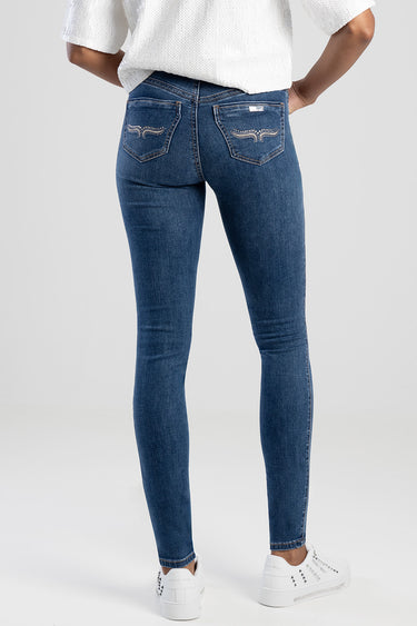 blue skinny jeans with embroidered back pockets, worn with a white top and white sneakers