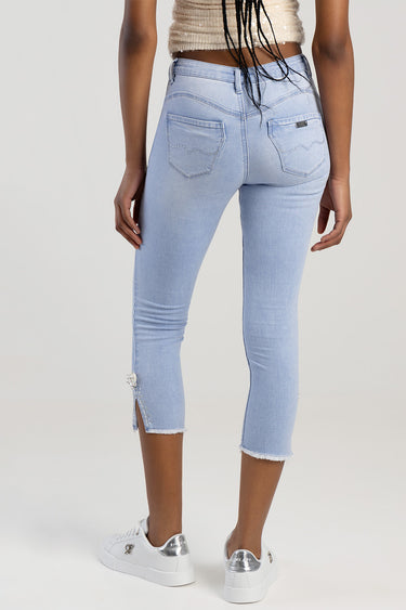 light blue capri jeans with back pockets and decorative stitching, frayed hems and bead embellishments at the ankle