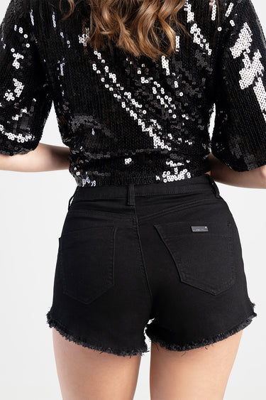 back view of black denim shorts with frayed hems, two back pockets and a small metal brand tag on the right pocket