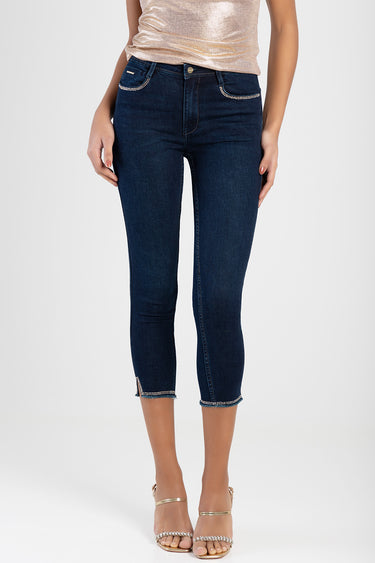 woman wearing dark blue capri jeans with rhinestone trim on pockets and cuffs, mid rise with a front button.