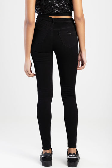 back view of a model in black skinny jeans with belt loops two back pockets and a small brand tag