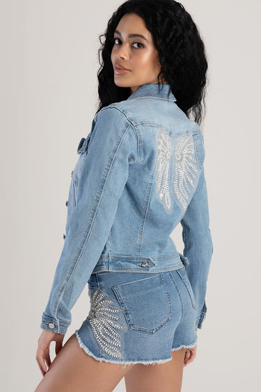 model wearing light blue denim shorts with rhinestone wing embroidery on pockets and leg, back view