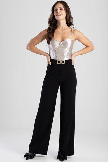 model wearing a silver bustier top with black high waist wide leg trousers and a gold belt buckle