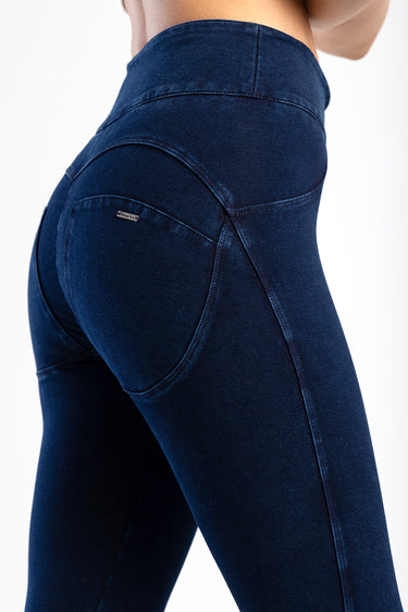 close up of blue jeans showing back pocket and curved seams on dark indigo denim with a small brand tag