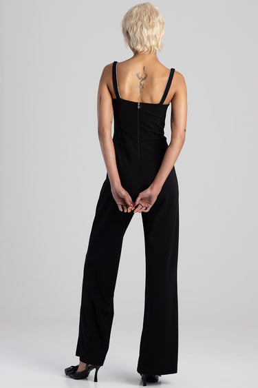back view of a person wearing a black wide leg jumpsuit with a back zipper and jeweled straps