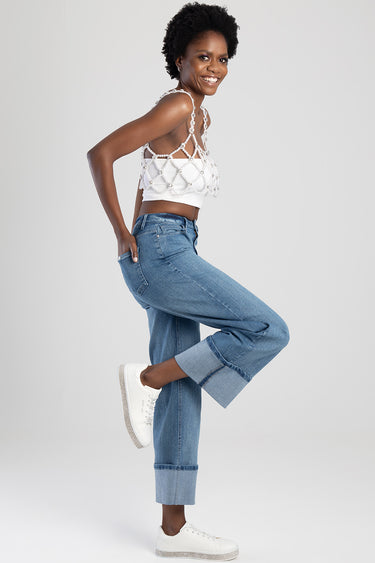 model in blue wide leg jeans with cuffed hems and white sneakers, wearing a pearl beaded crop top