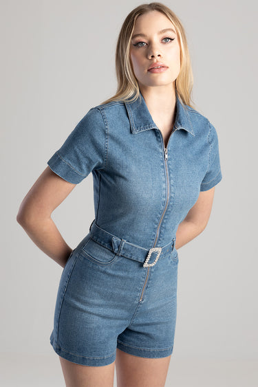 woman wearing blue denim playsuit with front zip and belt featuring a rhinestone buckle