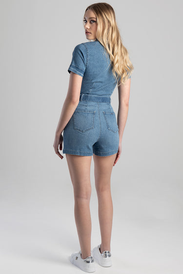 Blue Jean Traders denim playsuit with short sleeves and belt, back view on a model wearing white sneakers.