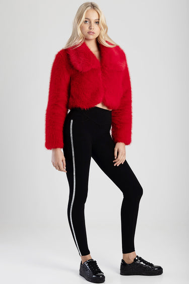model in a bright red fuzzy cropped jacket with black denim jeans featuring a silver rhinestone stripe and black glitter