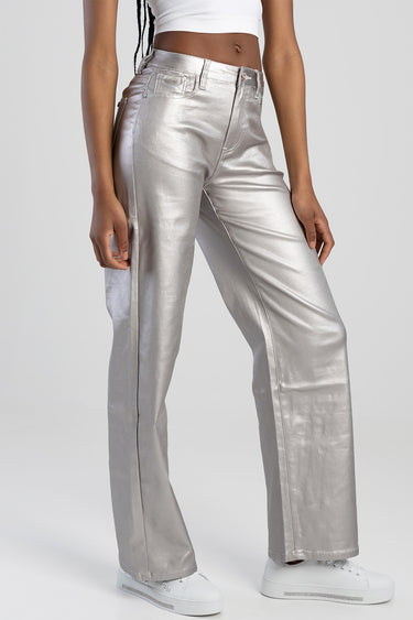 woman wearing silver metallic wide leg trousers with white sneakers by Blue Jean Traders