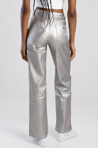 Blue Jean Traders metallic silver trousers viewed from behind with back pockets and white sneakers.