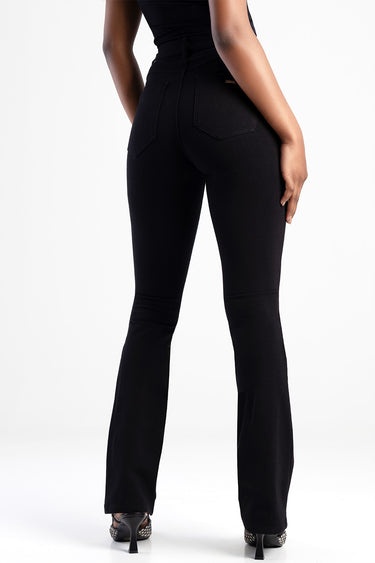 back view of a person wearing blue jean traders jeans in black denim with back pockets and a slight flare
