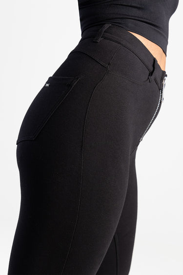 blue jean traders black denim jeans on a model, showing back pocket and side zipper detail, fitted high rise style