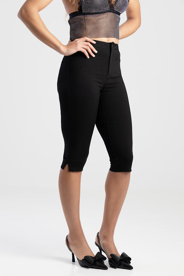 woman in black cropped denim jeans with a slim fit and small slit at the hem, wearing black heeled mules